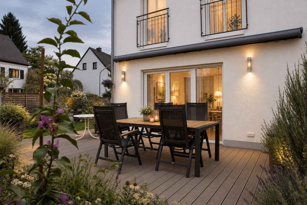 Terrasse mit Essplatz vor der hellen Fassade des Hauses in München-Laim