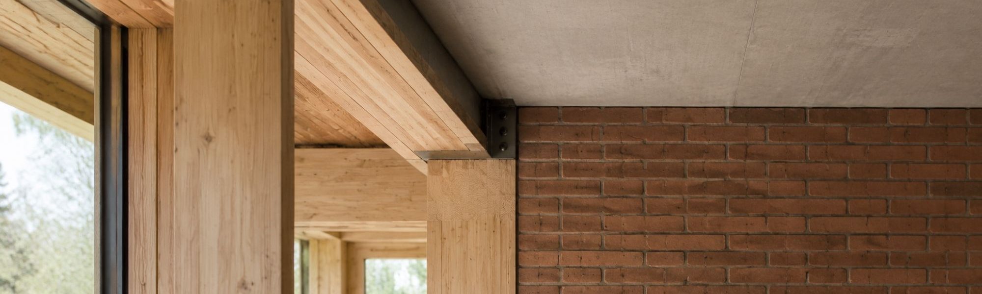 Materialdetail zum Hybridhaus mit Holzstütze, Ziegelwand und Betondecke